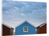 Beach huts in a row against sky by Assaf Frank